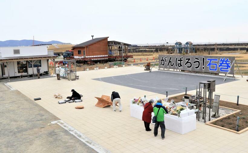 追悼行事が行われた「がんばろう！石巻」看板前の３月１２日の様子。片付けをする実行委員のほかは、時折手を合わせに来る人がいるだけで報道陣の姿はなかった（撮影／編集部・川口穣）