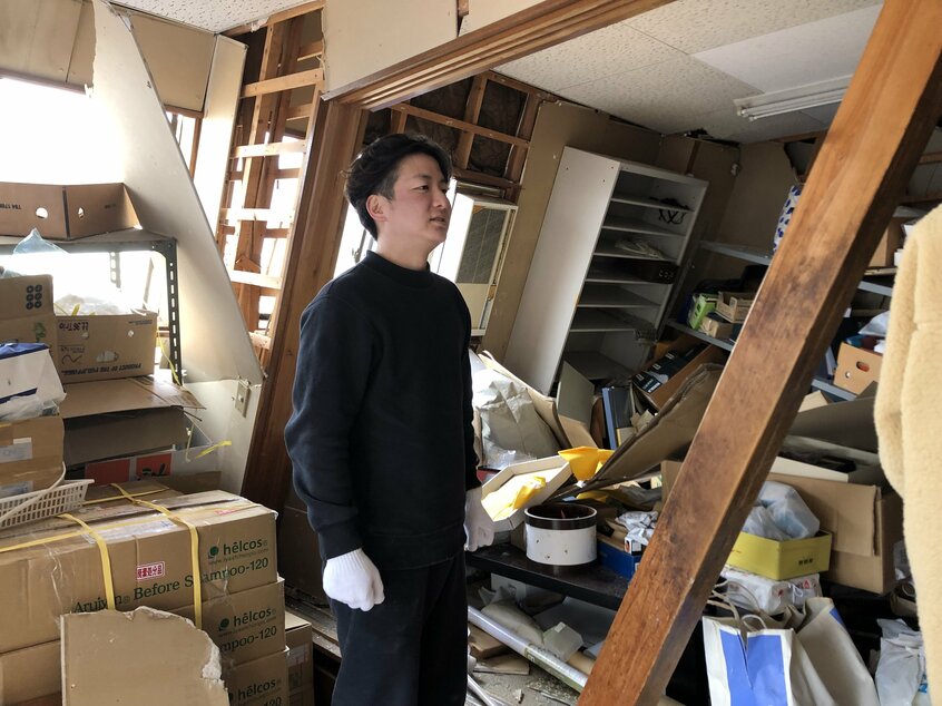 大きく傾く本社事務所棟で片付けをする田谷昂大さん。道路事情によりボランティアが入れず、災害ごみの収集が始まった時期だった(撮影/古川雅子)