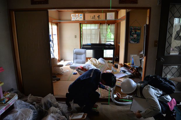 熊本支店熊本支社第二グループの宮下真明（左）が家屋の傾きを調べる。地震発生の１週間後から実調に入り、５月末までに５０件ほどを担当した（撮影／写真部・東川哲也）
<br />