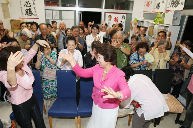 沖縄県議選で当選を決め、カチャーシーを踊って喜ぶ県政与党の女性候補。議席を減らしたのは「中立」会派だった／６月５日　（c）朝日新聞社