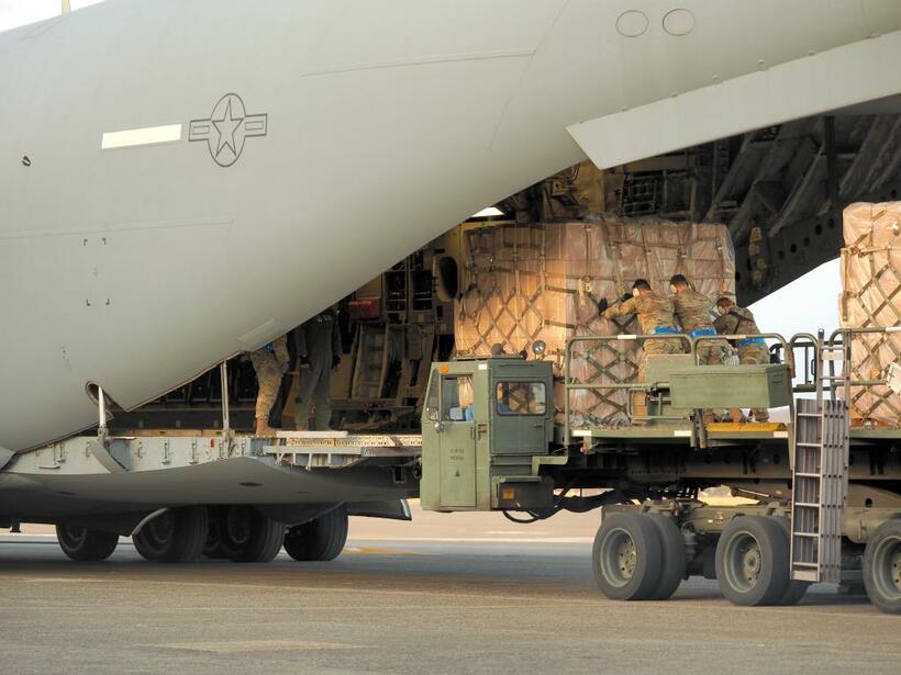 ３月１６日、横田基地で米軍のＣ１７輸送機に自衛隊物資を積み込む米軍兵士ら