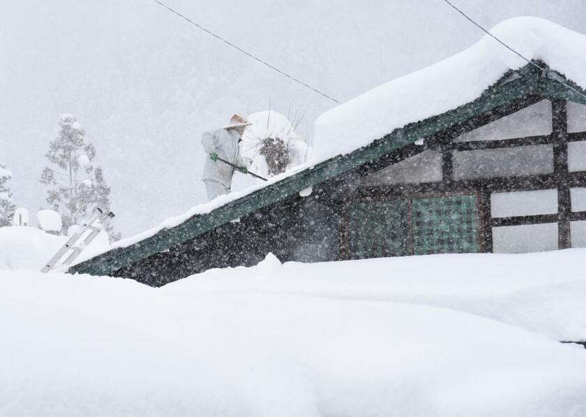 屋根の雪下ろしをする住民