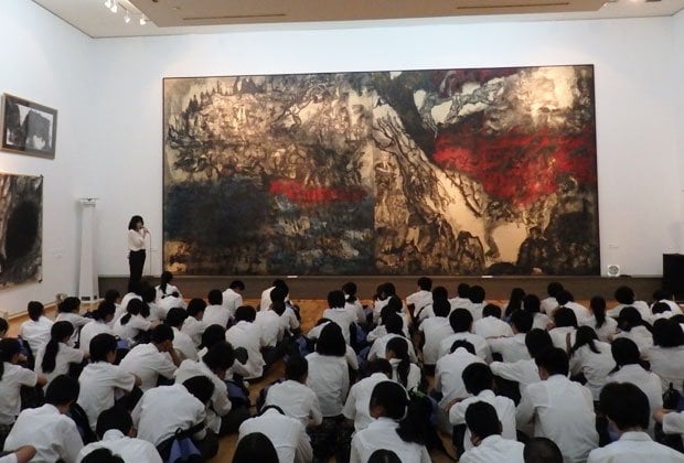 修学旅行で訪れた中学生を前に、「沖縄戦の図」について解説する佐喜眞美術館の上間かな恵さん。「『戦争はいけないと思います』という感想文で終わらせず、『気づき』を持ち帰ってほしいですね」（撮影／渡瀬夏彦）