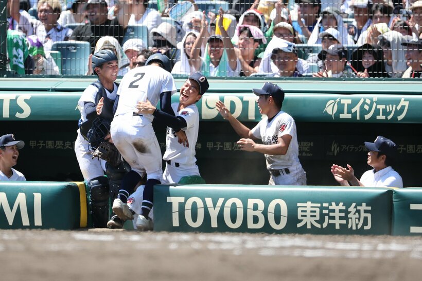 七回裏、沖縄尚学・比嘉の適時打で勝ち越しの本塁を踏んだ宜野座（背番号2）がベンチから祝福を受ける（撮影／写真映像部・馬場岳人）
