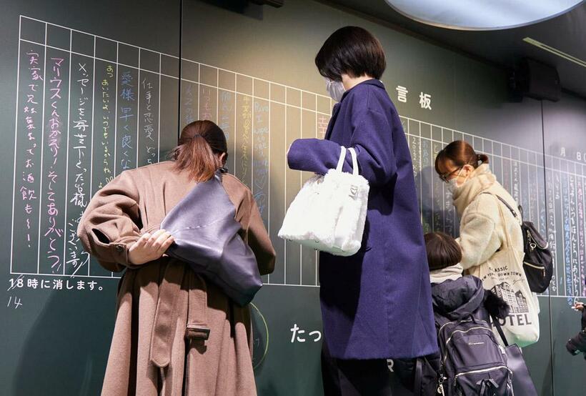 年末年始に池袋駅に設置された伝言板と書き込む人たち