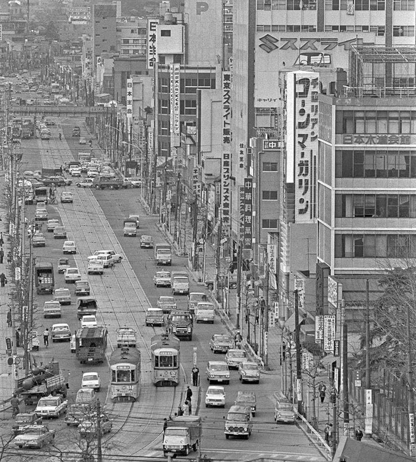 日大経済学部の校舎から俯瞰した白山通りで行き交う17系統池袋駅前行きと数寄屋橋行きの都電。画面左奥に営団地下鉄（現東京メトロ）丸ノ内線の跨道橋が見える。右側の七階建てのビルが、筆者が実習授業に通った日本水道会館。（撮影／諸河久：1968年3月12日）