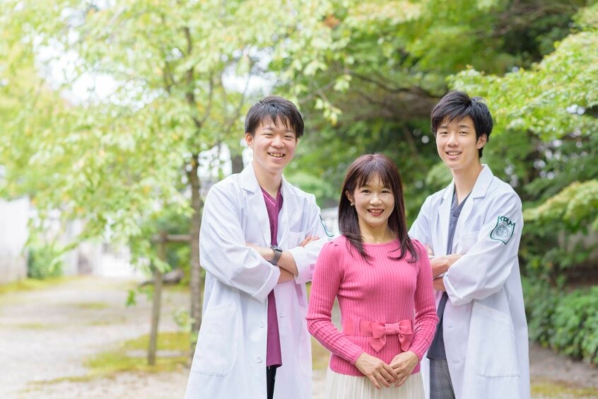 子育てアドバイザーの藤田敦子さん(中央)と医学部現役合格を果たした息子2人。「働く親は、学費を稼ぐために働く自分を偉いと褒めましょう」(藤田さん)(写真/藤田さん提供)