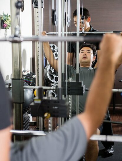 個室でマシンを使って背中の筋肉を鍛える筆者。トレーナーが個別指導してくれる/RIZAP六本木店(撮影/写真部・堀内慶太郎)