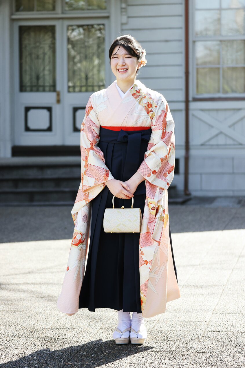 四季の花が描かれた桜色の本振袖が風になびくさまが美しく、紺色の袴がすっきりとした若々しさを引きたてる=3月20日、東京都豊島区、代表撮影/JMPA