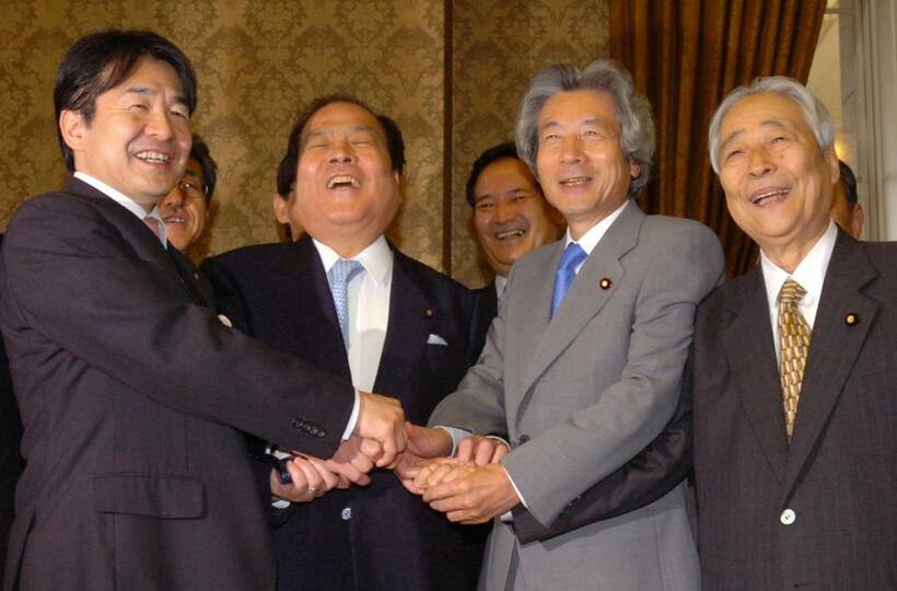 郵政民営化関連法が成立し、握手する小泉純一郎首相と青木幹雄参院議員会長ら（肩書はいずれも当時）
