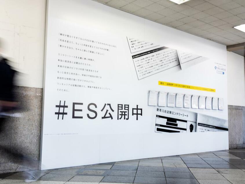 渋谷駅の東京メトロ銀座線改札口に出現したワンキャリアの壁面広告。足を止めて見入るリクルートスーツ姿の学生もいた（写真：ワンキャリア提供）