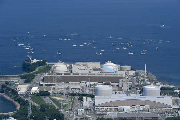 ２０１７年１月に再稼働が認められた佐賀・玄海原発。海上には、再稼働に反対して集結した漁船が見られる　（ｃ）朝日新聞社