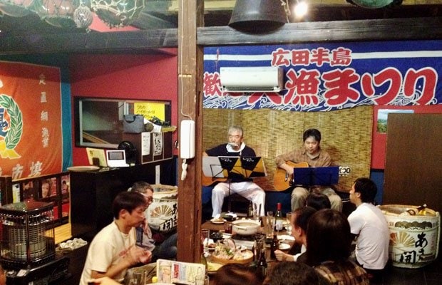 陸前高田俺っ家で演奏をする熊谷さん(左)と、実行委員会メンバーで映画監督の高橋政彦さん。