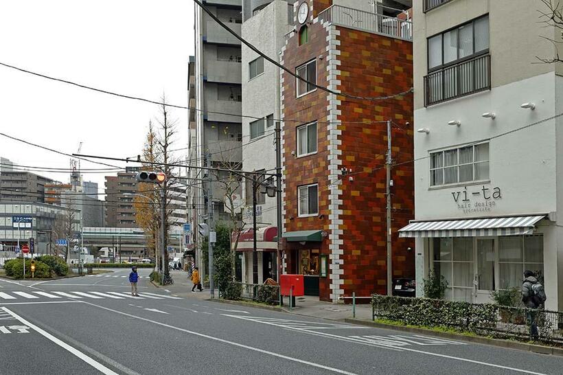 郵便ポストの位置を手掛かりにして、かつての撮影地を探った。旧景の芝三田松坂町郵便局は空き地になっており、その左側にかめがや時計店の建物が隣接している（撮影／諸河久：2020年1月7日）