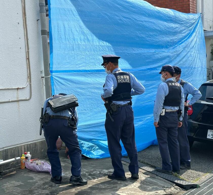 祖母が監禁されていた賃貸住宅に集まる警察官＝6月24日、神戸市