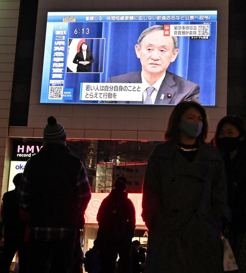 緊急事態宣言が出され、街頭の大型ビジョンに菅義偉首相の記者会見が映し出された＝２０２１年１月７日　（ｃ）朝日新聞社