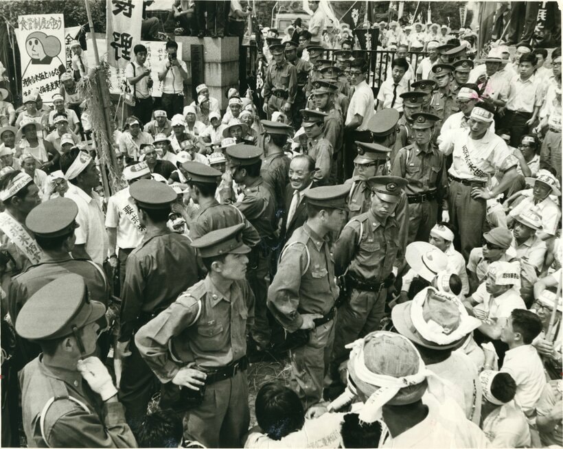 1968年　米価審議会。会場前に座り込んだ農民団体と警備の警官隊