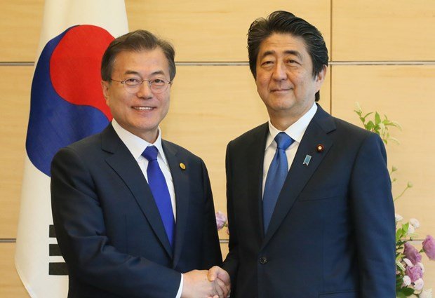 韓国の文在寅大統領（左）と握手する安倍晋三首相　（ｃ）朝日新聞社