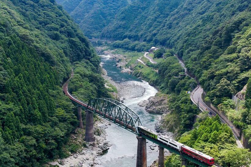 鉄橋に差し掛かる瞬間は、鉄道ファンならずとも気分が高揚する。時刻表を読んで目を閉じれば、こんな情景も浮かんできそうだ。写真は、吉野川にかかる「第二吉野川橋梁」を渡るＪＲ四国土讃線の車両（写真：徳島河川国道事務所提供）