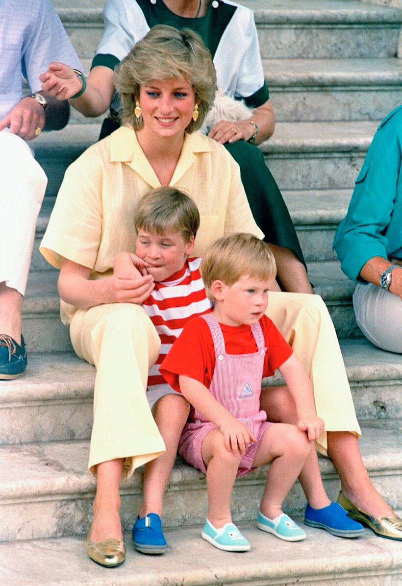 1987年8月9日、スペインのマヨルカ島にある王宮の階段で、ウィリアム王子（当時）とヘンリー王子と一緒に座り、微笑むダイアナ元妃（photo AP/アフロ)